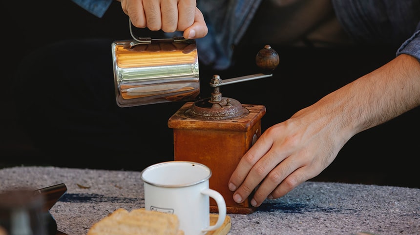 a-man-adding-coffee-beens-in-coffee-grinder