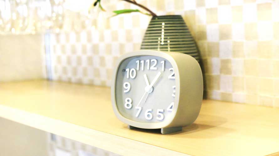 analog clock on a kitchen shelf