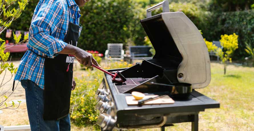 A man cleaning gas grill