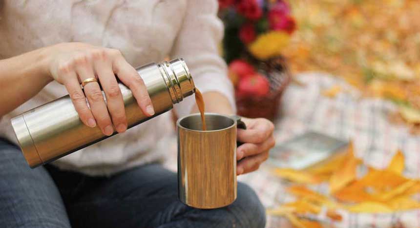 A girl pouring coffee in a cup from coffee thermos
