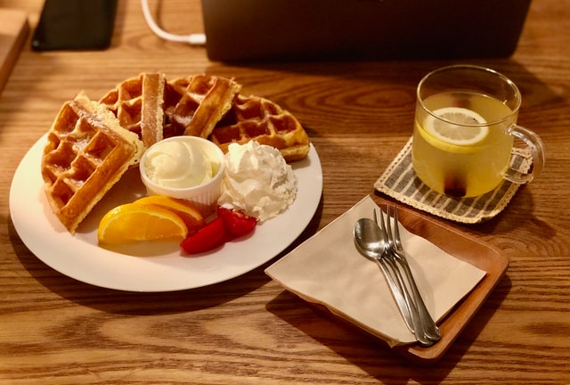 waffles in a plate with some mayo & cream on a table