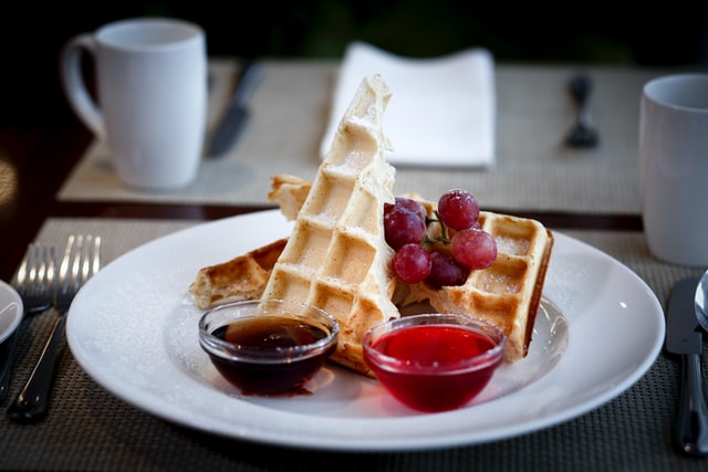 waffles in a plate with some berries & sauces