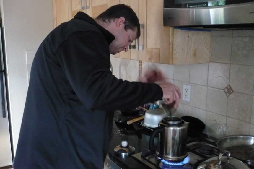a man making coffee in percolator putting it on stove