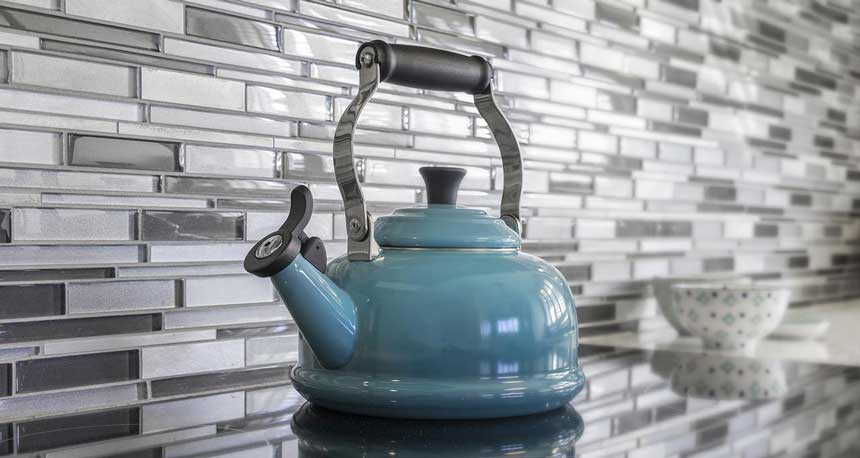 Gray colored tea kettle on kitchen shelf