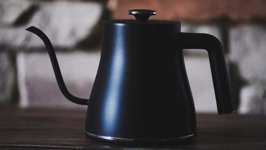 black gooseneck kettle on a wooden table