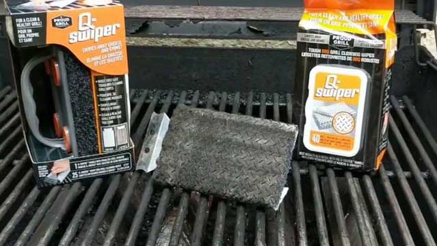 A grill cleaner brush with packaging around on a grill