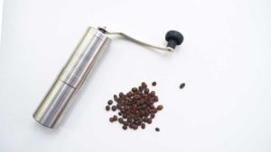 Stainless steel manual coffee grinder with coffee beans side by