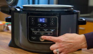 man setting temperature on electric cooker