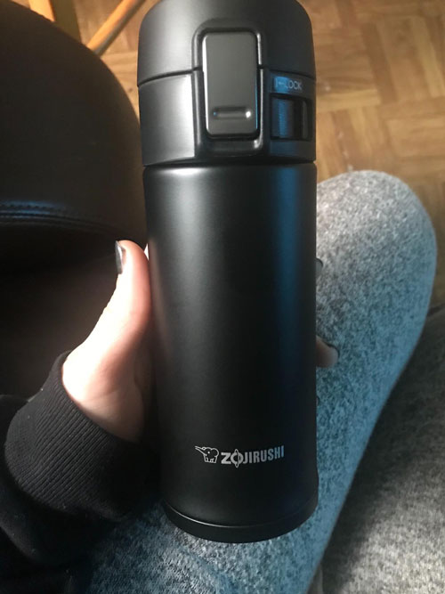 girl holding the zojirushi stainless steel thermos in her hands