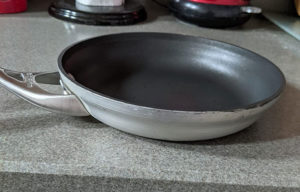 Close up a Calphalon Contemporary Hard-Anodized Aluminum Nonstick Omelette Pan on kitchen shelf
