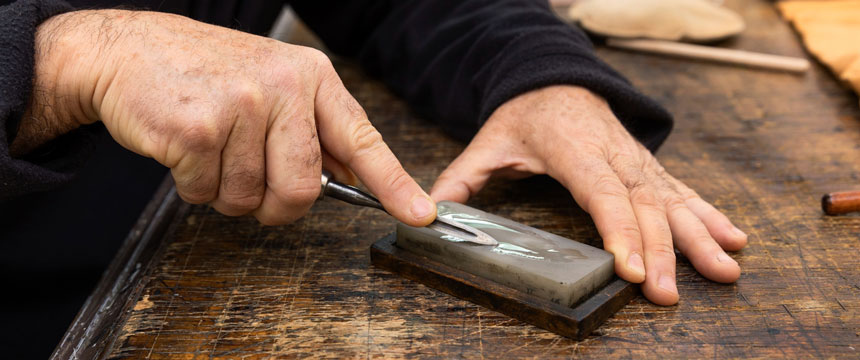 Man sharpening a knife with sharpening stone