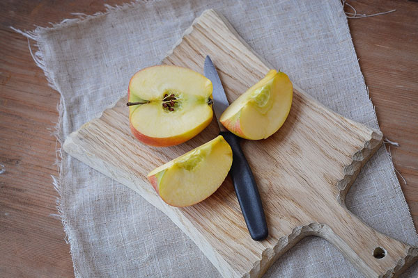 knife with sliced apple on a cutting board