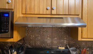 Close up of Cosco under cabinet range hood fixed under a cabinet in a kitchen