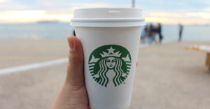 Close up of a hand holding starbucks coffee cup