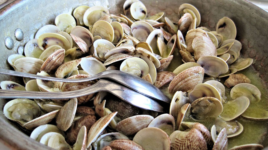steamed clams in a bowl with spoons